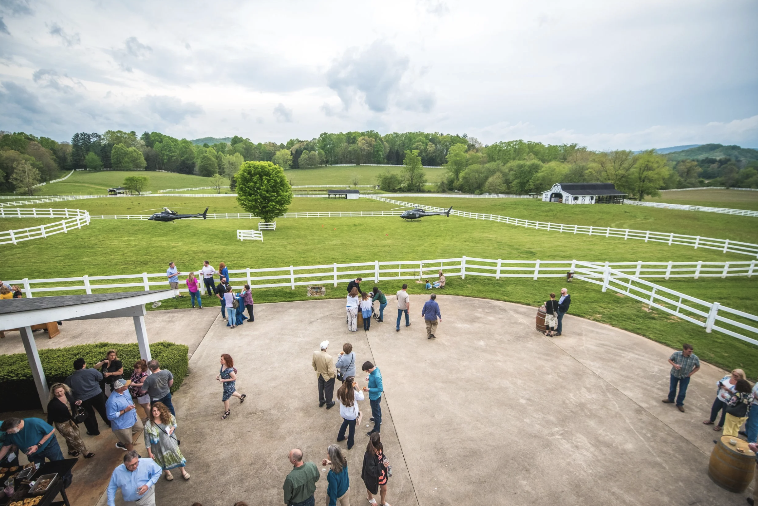 Guests gathered at an event with helicopters on the lawn