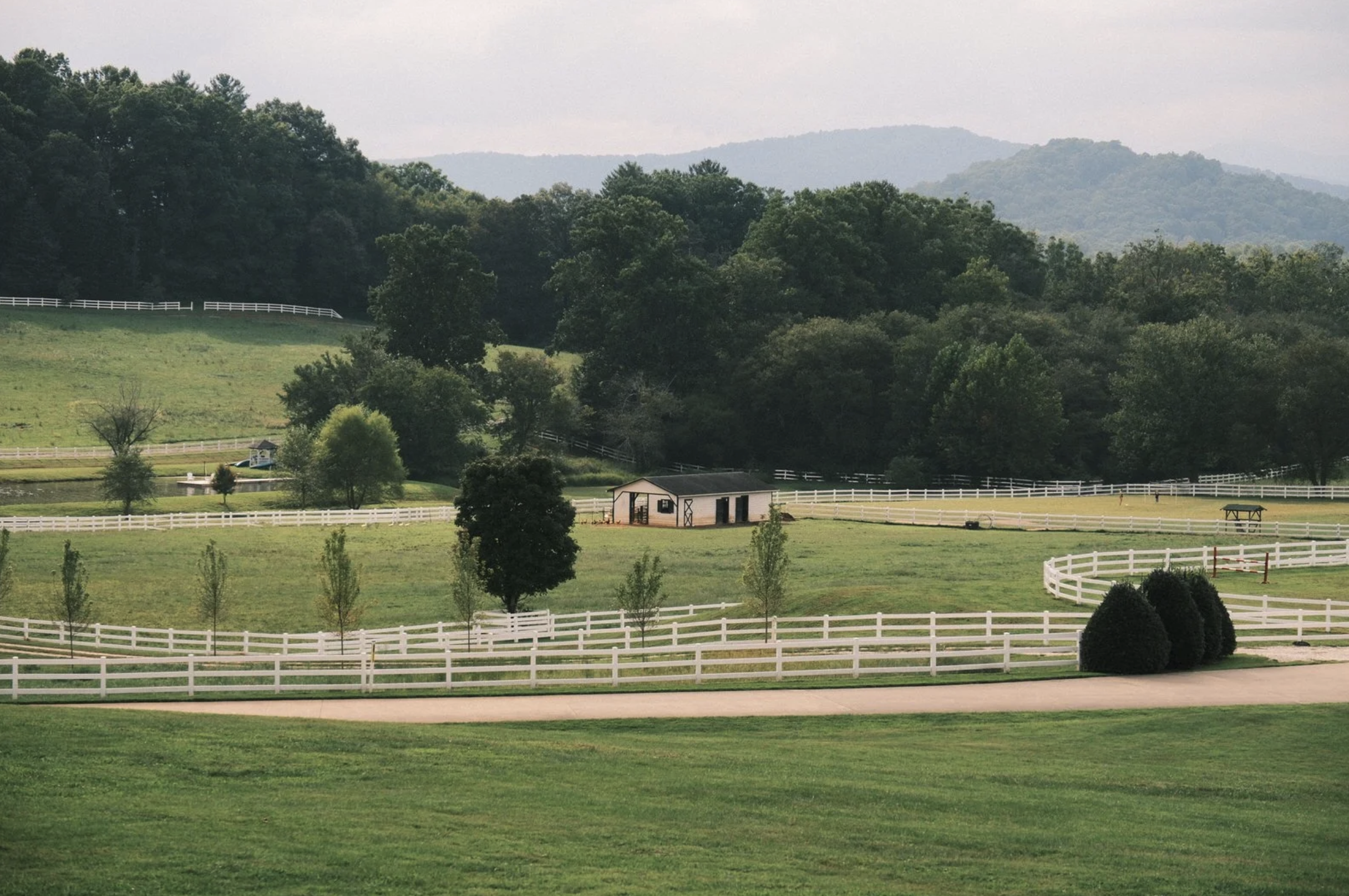 White-fenced paddocks with a stable
