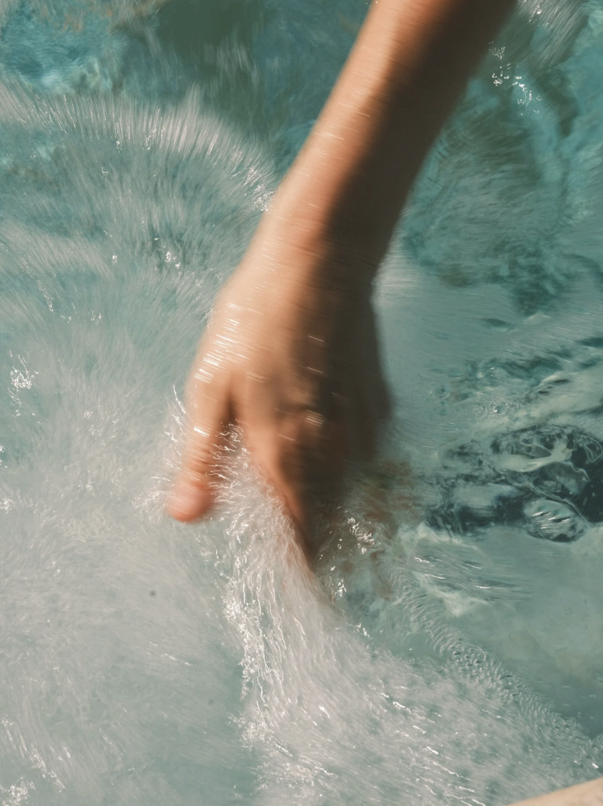 Hand moving through the hot tub