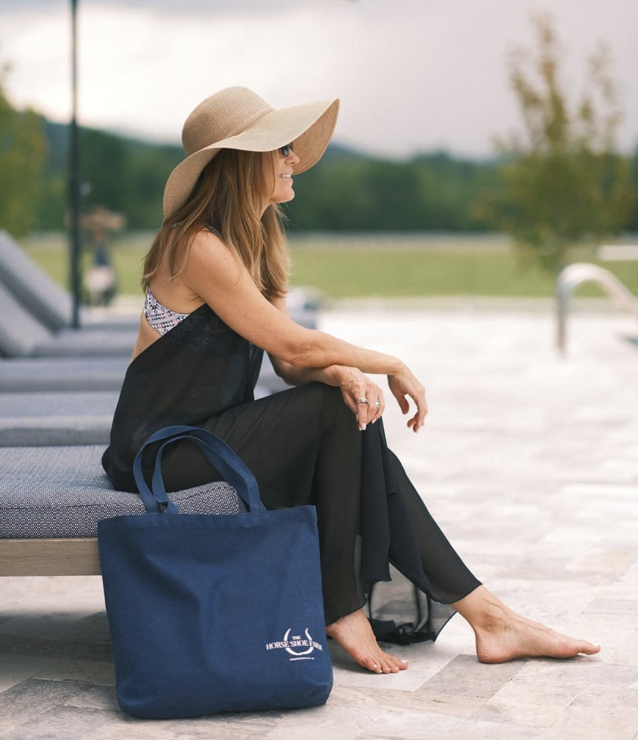 Guest by the pool with a navy tote