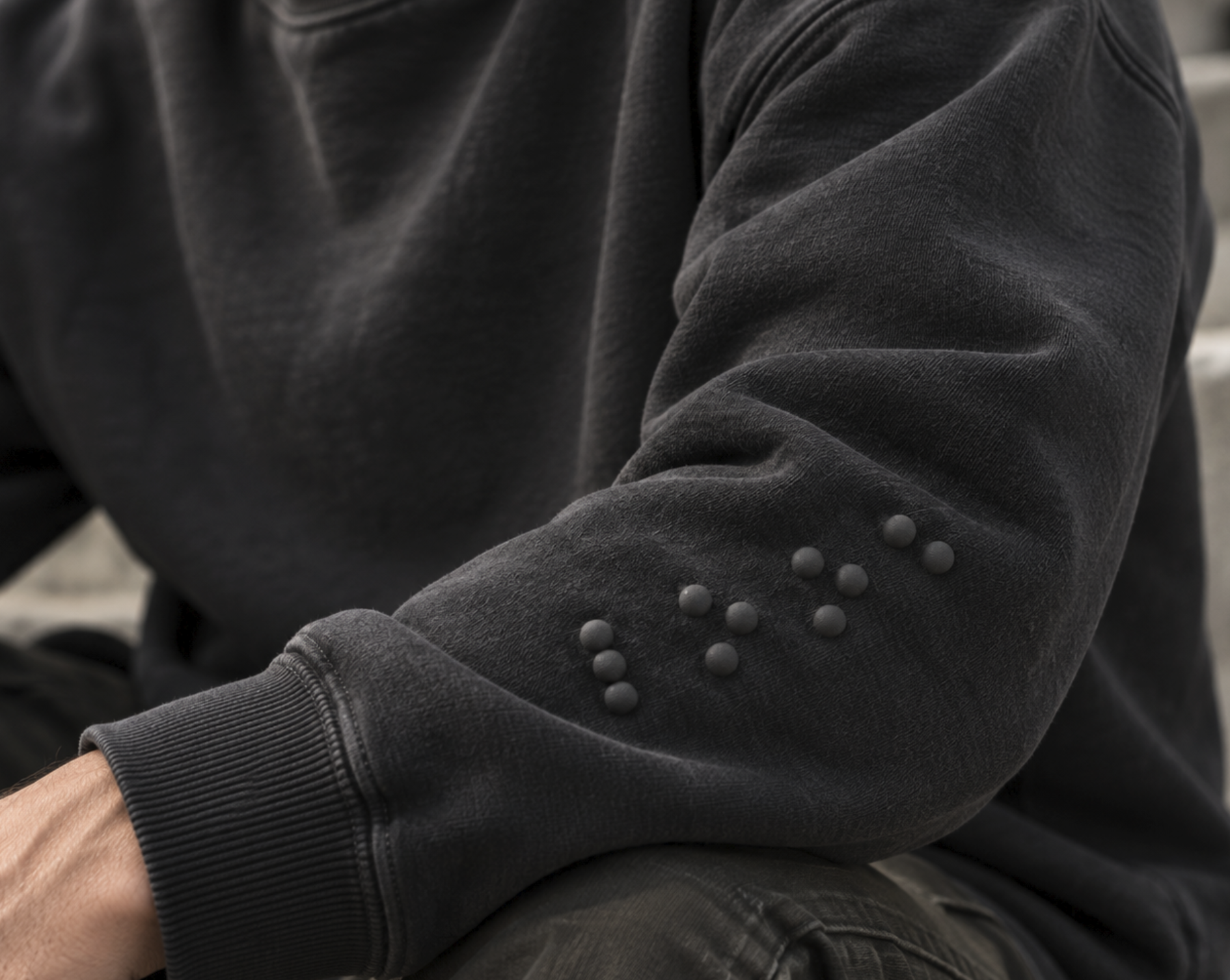 Black sweatshirt sleeve with raised braille dots