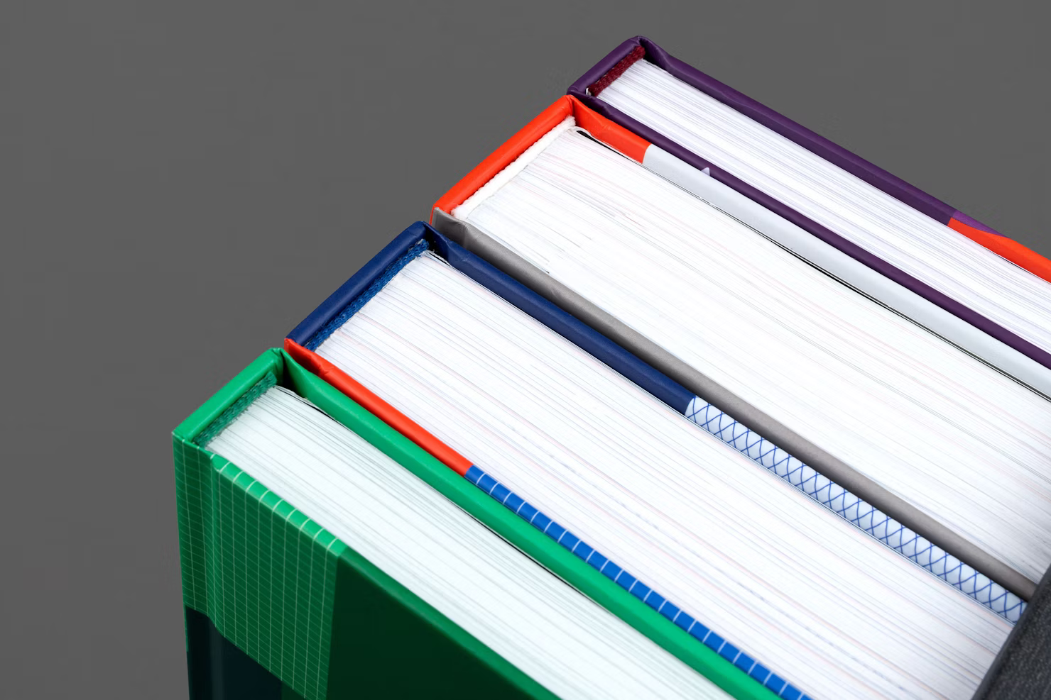 Four volumes stacked, spine colours visible on the top edge
